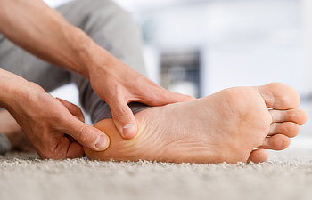 man hands giving foot massage to yourself after a long walk